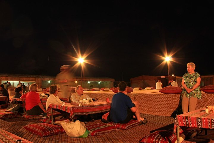 Experience an unforgettable evening under the stars enjoying local cuisine and entertainment at a desert camp surrounded by the serene beauty of the Dubai desert landscape.